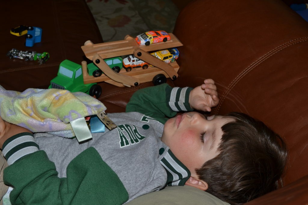 napping with his cars and trucks